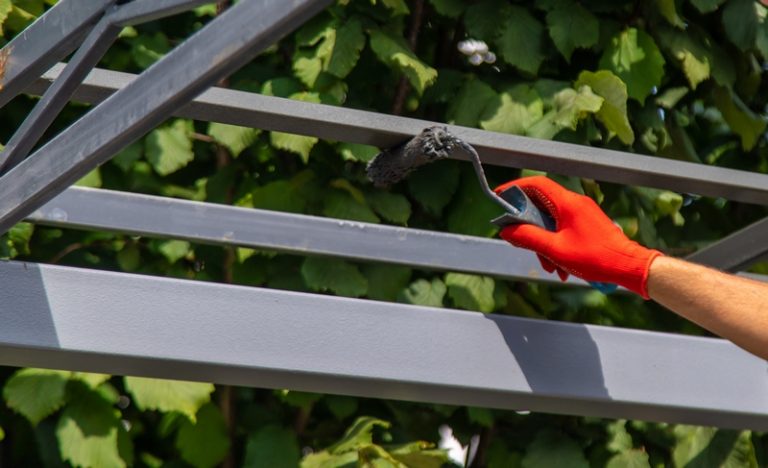 personne qui repeint une pergola